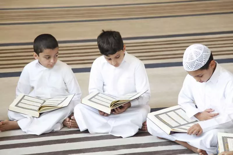 A group of children learning the Holy Quran